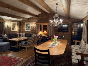 a living room with a table and chairs and a chandelier at Large cottage with beautiful view in Trysil in Trysil