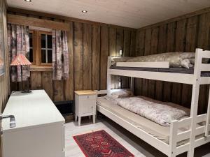 a bedroom with two bunk beds and a desk at Large cottage with beautiful view in Trysil in Trysil