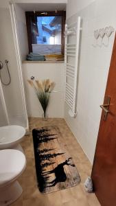 a bathroom with a toilet and a rug on the floor at Maison Cavalese - Polar Express in Cavalese +12 photos