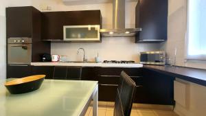 a kitchen with black cabinets and a table and a sink at Casa di Giada - Venice Gateway - Family Comfort - Free Public Parking& Tram -Link in Mestre