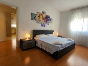 a bedroom with a bed and two lamps on tables at Casa di Giada - Venice Gateway - Family Comfort - Free Public Parking& Tram -Link in Mestre