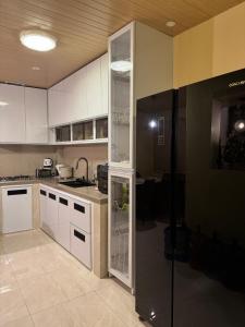 eine Küche mit einem Kühlschrank, dessen Tür offen ist in der Unterkunft Armi's Place - General Trias Cavite in Sampong + 17 Fotos
