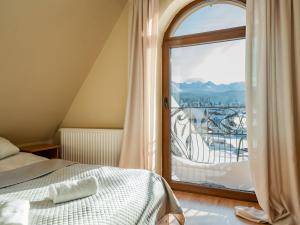 a bedroom with a bed and a large window at Willa TOSKA in Murzasichle