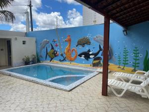 a mural of a swimming pool in a house with an ocean at Casa grande in Garanhuns