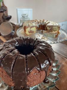 a chocolate bundt cake on a table with other desserts at Porto Pousada com café in Imbituba