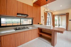 a kitchen with wooden cabinets and a sink and a window at Golden Villa Lovina in Lovina
