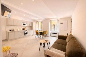 a living room and kitchen with a couch and a table at Appartement T3 Place du Marché in Bastia
