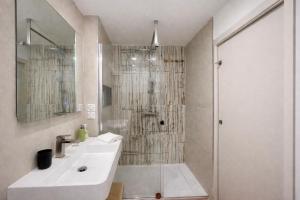 a white bathroom with a shower and a sink at Appartement T3 Place du Marché in Bastia +24 photos