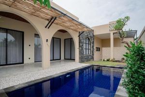 a villa with a swimming pool in front of a house at Golden Villa Lovina in Lovina