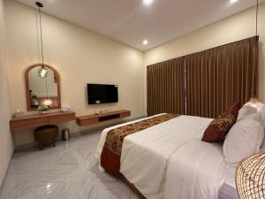 a bedroom with a large bed and a television at Golden Villa Lovina in Lovina