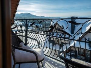 a balcony with chairs and a view of the water at Willa TOSKA in Murzasichle