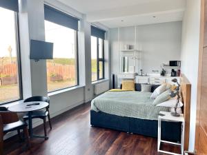 a bedroom with a bed and a table and some windows at School house Portaferry in Portaferry