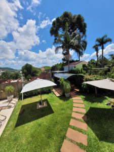 a garden with two umbrellas and grass at Pousada Casa Thede in São Salvador