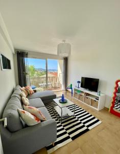 a living room with a couch and a tv at Casa Dolce Giens - Parenthèse ensoleillée vue mer ! in Hyères