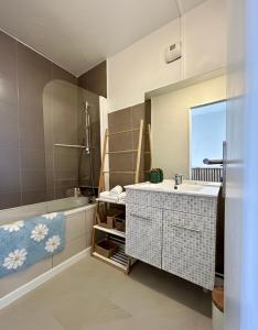 a bathroom with a sink and a tub and a mirror at Casa Dolce Giens - Parenthèse ensoleillée vue mer ! in Hyères