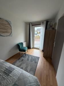 a bedroom with a green chair and a window at Studio indépendant Lisieux in Lisieux