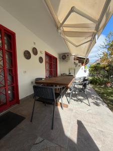 a patio with a wooden table and chairs under an umbrella at Cozy Garden by the Beach in Playa del Cura