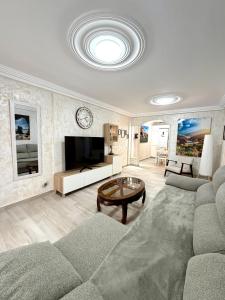 a living room with a couch and a tv at Cozy Garden by the Beach in Playa del Cura