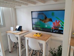 a room with two tables and a tv and a laptop at Urdaneta City Modern Condo in Bayaoas
