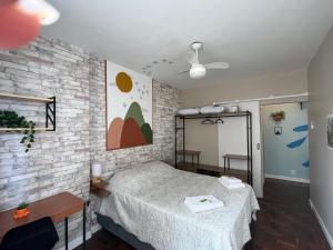 a bedroom with a bed and a brick wall at Apartamento Charme da Glória in Rio de Janeiro
