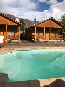 a house with a pool in front of it at Cabañas El bosque DLM in Uspallata +8 photos