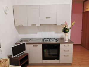 a small kitchen with a stove and a tv at Dimora Venice Station in Mestre