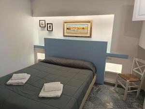 a bedroom with a blue bed and a chair at Locanda B&B Dandana in Orgosolo