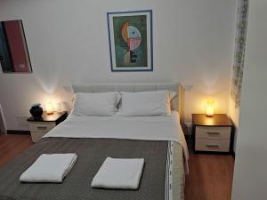 a bedroom with a large bed with two night stands at Dimora Venice Station in Mestre