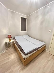 a small bedroom with a bed and a lamp at Cozy Apartment in Central Alesund Close to Everything in Ålesund
