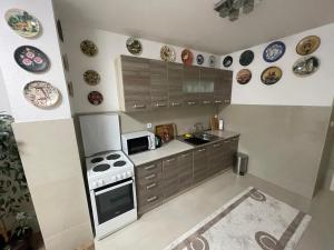 a kitchen with a stove and plates on the wall at Apartman Deluxe in Novi Travnik