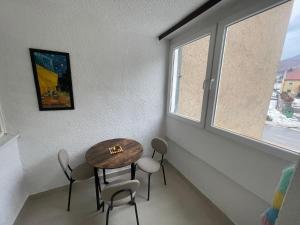 a small table and chairs in a room with a window at Apartman Deluxe in Novi Travnik