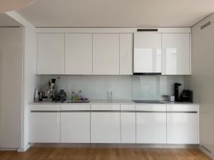 a white kitchen with white cabinets and appliances at Zurich City Appartement in Zurich