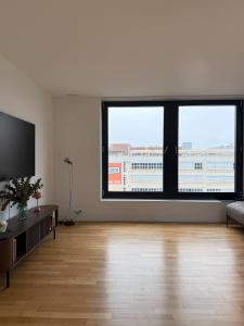 an empty living room with two large windows at Zurich City Appartement in Zurich