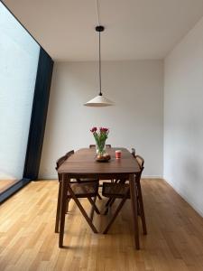 a dining room table with a vase of flowers on it at Zurich City Appartement in Zurich +3 photos