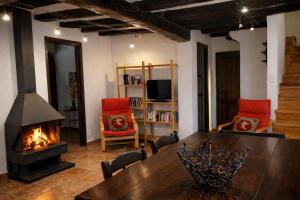 ein Wohnzimmer mit einem Tisch und einem Kamin in der Unterkunft Casa amb vista a les muntanyes - Cal Valeri in Montsonis