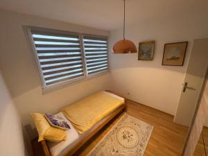 a small bedroom with a bed and a window at Apartman Deluxe in Novi Travnik +3 photos