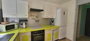 a kitchen with a white refrigerator and a microwave at Escale caraibe in Le Gosier