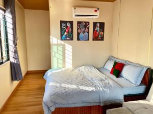 a small bedroom with a bed and pictures on the wall at Mộc Homestay - Mộc Châu in Mộc Châu +53 photos