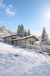 ein schneebedecktes Haus davor in der Unterkunft Hedera Sovata in Sovata
