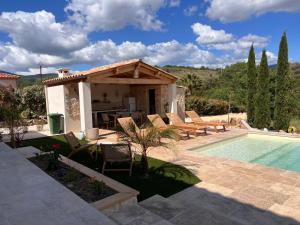 a villa with a swimming pool and a house at Villa Signature in Le Bosc