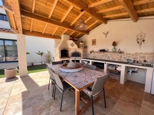 a kitchen with a table and chairs and a counter at Villa Signature in Le Bosc