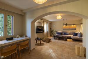 a living room with a couch and a table at Apeiron Villas - Olive Forest Apartment in Kefallonia