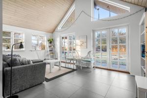 a living room with a couch and chairs and windows at Feriehus 1150 in Ringkøbing