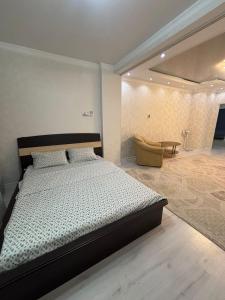 a bedroom with a bed and a chair in it at высотка 15 in Aktobe