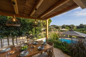 an outdoor dining table with a view of a pool at Apeiron Villas - Olive Forest Apartment in Kefallonia