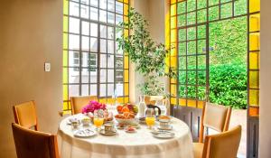 Un comedor con mesa y sillas y ventanas. en Casa Sur - 400 m from the park at most elegant neighbourhood in Mendoza City, en Mendoza
