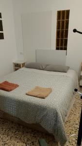 a bedroom with a bed with two towels on it at Habitaciones Yanet in La Granada