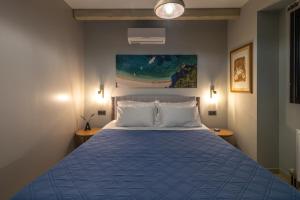 a bedroom with a blue bed with two pillows at Apeiron Villas - Olive Forest Apartment in Kefallonia +34 photos
