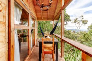 a wooden house with a table and chairs on a porch at Refugio para desconectar, cabaña del ermitaño en medio del bosque in La Ceja