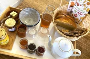 a table with a basket of bread and a basket of honey at Grange de la Côle in Saint-Jean-de-Côle